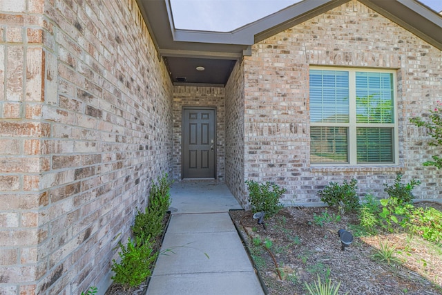 property entrance featuring brick siding