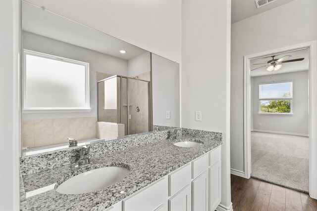 bathroom featuring ceiling fan, wood-type flooring, an enclosed shower, and dual bowl vanity