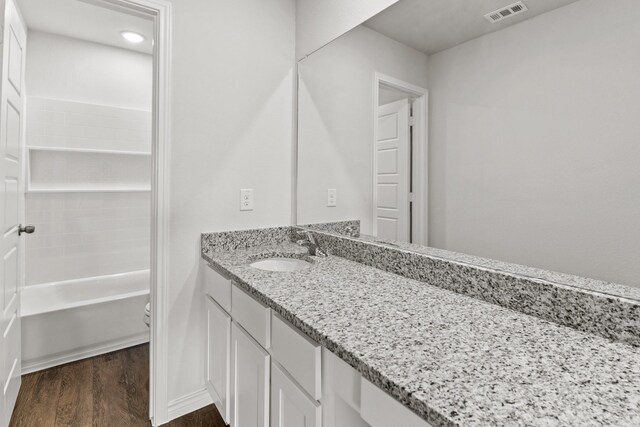 full bathroom featuring bathing tub / shower combination, hardwood / wood-style flooring, toilet, and vanity