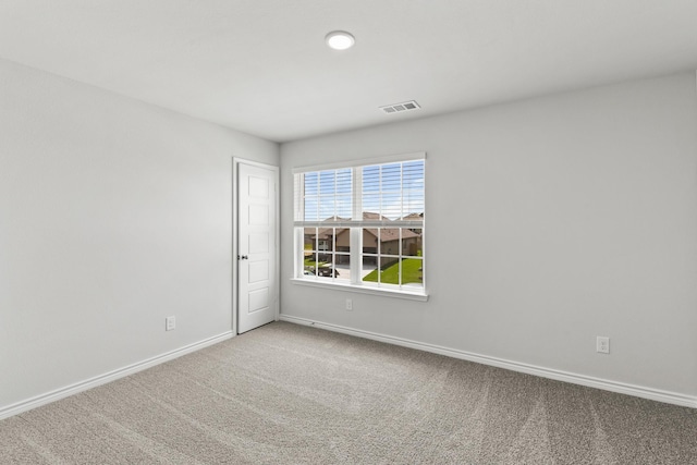 empty room with baseboards, visible vents, and carpet flooring