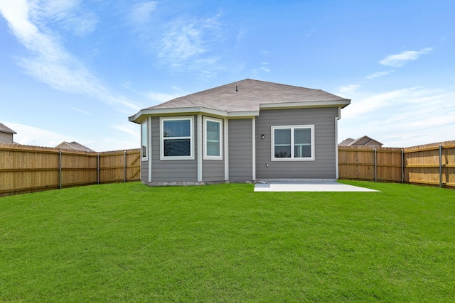 rear view of house with a yard, a fenced backyard, and a patio