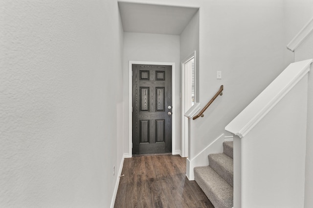 foyer featuring stairs, baseboards, and dark wood-type flooring