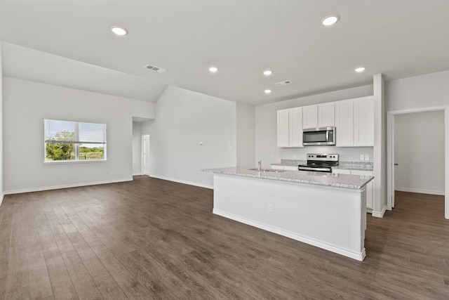 kitchen featuring stainless steel appliances, dark hardwood / wood-style floors, light stone counters, an island with sink, and white cabinets