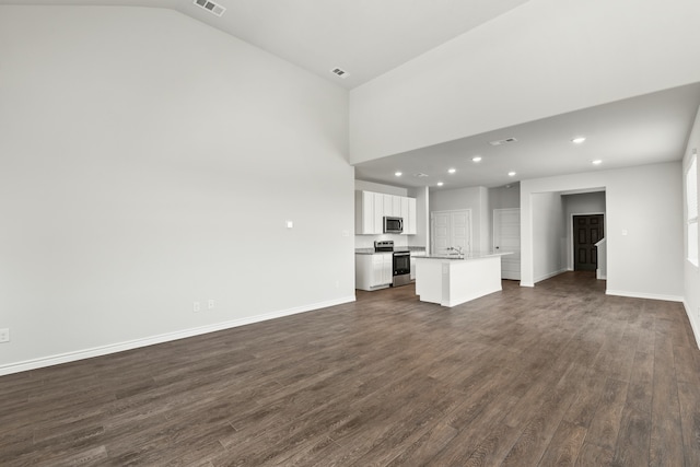 unfurnished living room with sink, dark wood-type flooring, and lofted ceiling