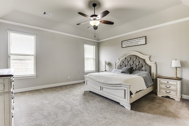 carpeted bedroom featuring a tray ceiling and ceiling fan