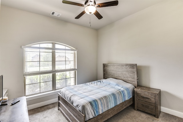 bedroom with ceiling fan, multiple windows, and light colored carpet