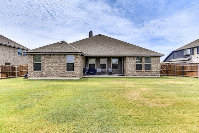 rear view of property with a patio and a lawn