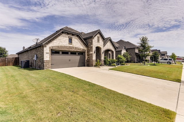 french provincial home with a garage, central air condition unit, and a front lawn