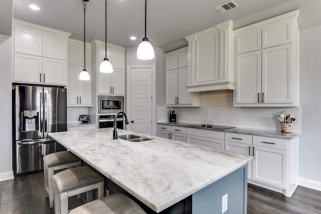 kitchen with backsplash, sink, appliances with stainless steel finishes, and decorative light fixtures