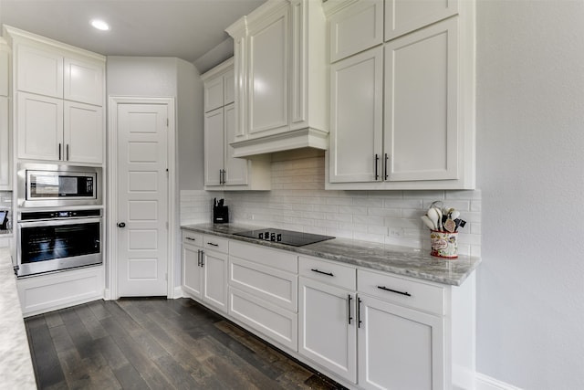 kitchen featuring dark hardwood / wood-style floors, stainless steel appliances, tasteful backsplash, and light stone counters