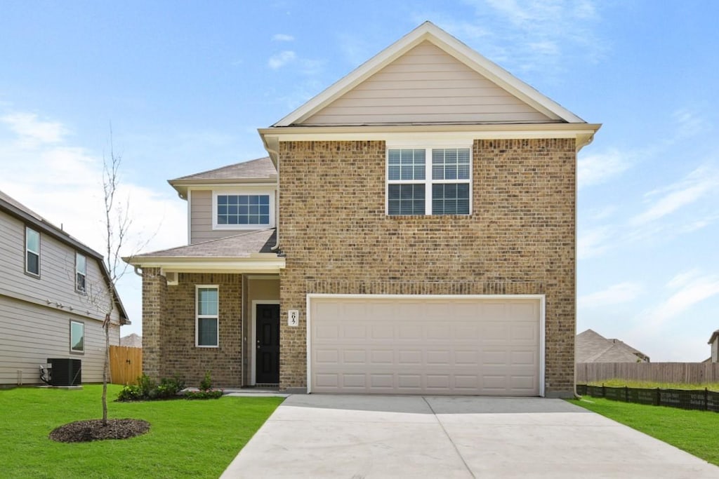 front facade featuring central air condition unit, a garage, and a front lawn