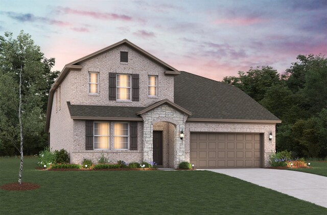 view of front of home with a garage and a yard