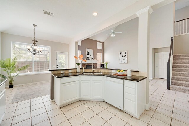 kitchen featuring dishwasher, sink, white cabinetry, vaulted ceiling, and light tile patterned floors