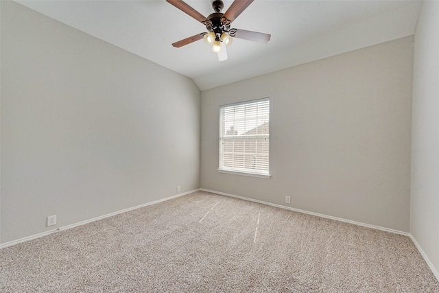 carpeted spare room featuring ceiling fan and vaulted ceiling