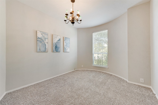 carpeted empty room with a chandelier