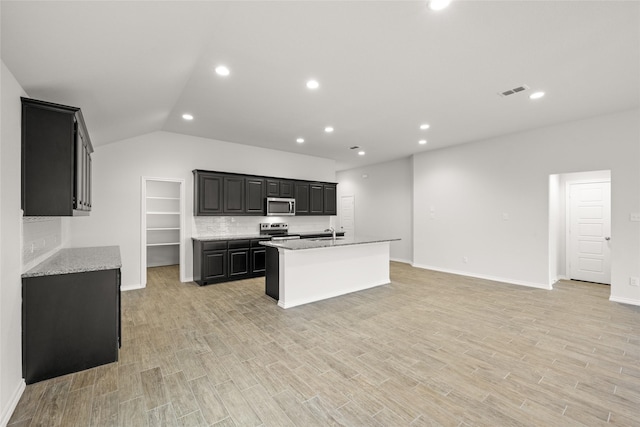 kitchen featuring appliances with stainless steel finishes, sink, a center island with sink, and light wood-type flooring