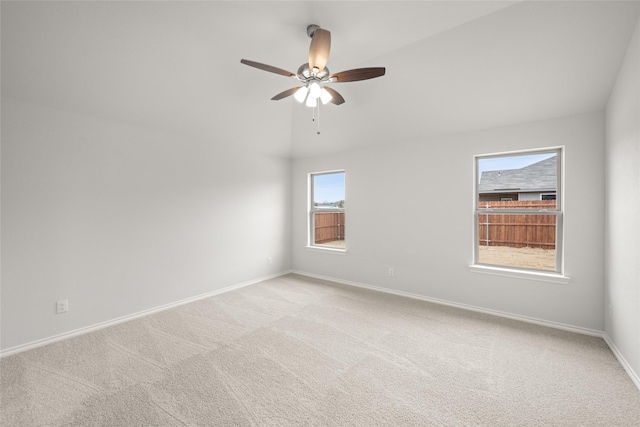 empty room with lofted ceiling, light colored carpet, and ceiling fan