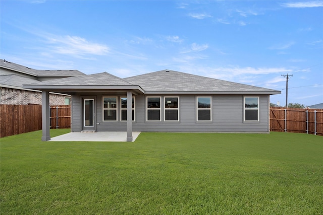 rear view of house with a lawn and a patio