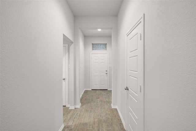 hallway with light hardwood / wood-style flooring