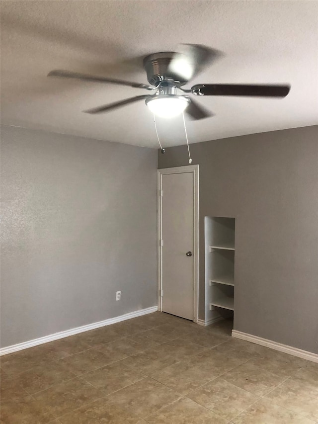 unfurnished bedroom with ceiling fan and tile patterned floors