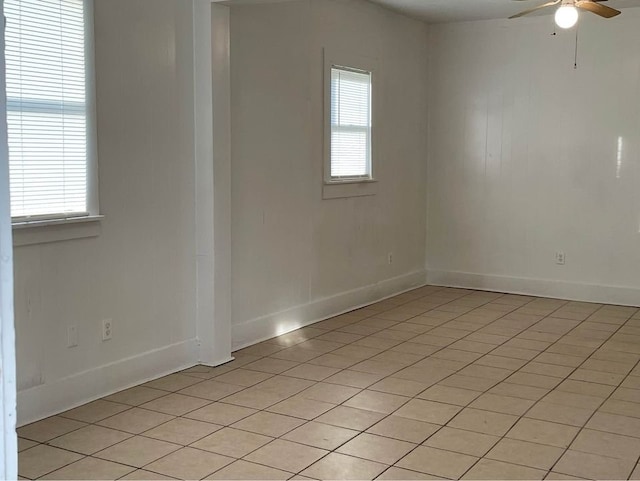 spare room with ceiling fan, light tile patterned floors, and a wealth of natural light