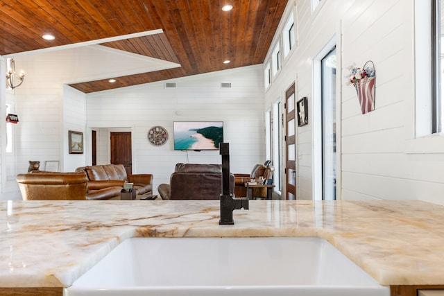 kitchen featuring sink, vaulted ceiling, wood walls, and wood ceiling