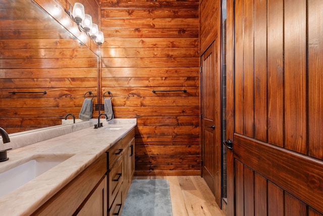 bathroom with vanity, hardwood / wood-style floors, and wood walls