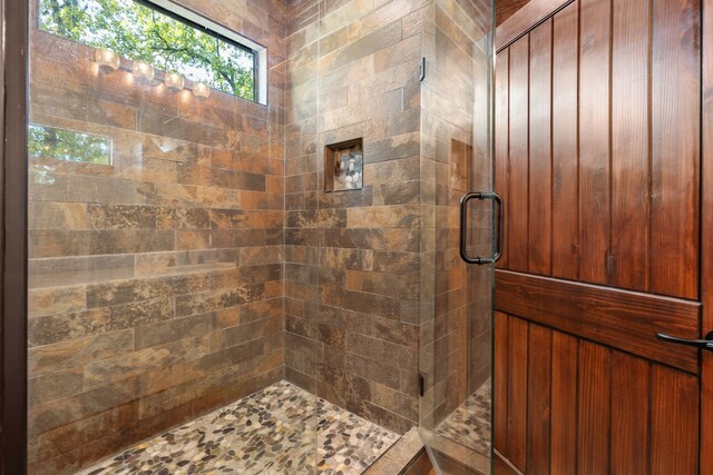 bathroom with a shower with door