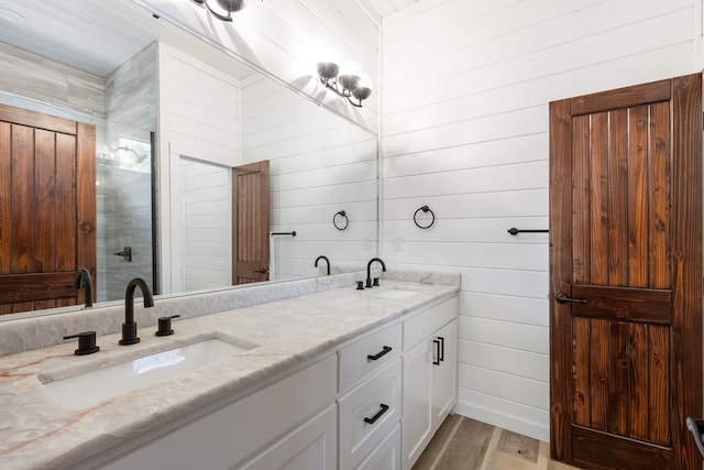 bathroom with vanity, wood walls, and wood-type flooring