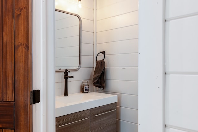 bathroom featuring wood walls and vanity