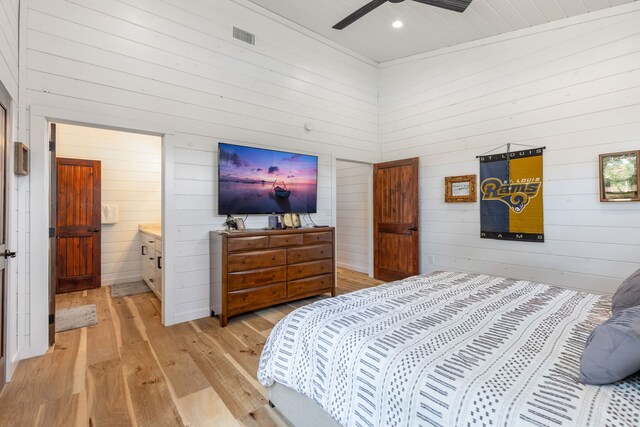 bedroom with light hardwood / wood-style floors, ensuite bath, and ceiling fan