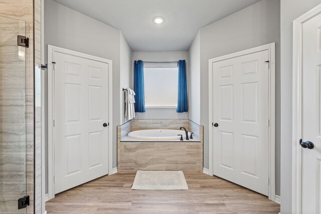 bathroom featuring ceiling fan, hardwood / wood-style flooring, a tile shower, and vanity