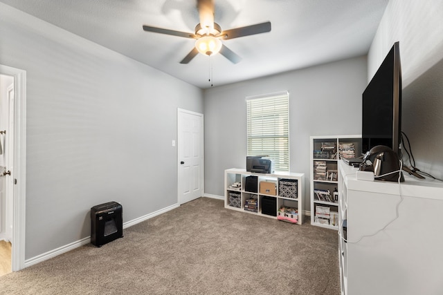 carpeted home office featuring ceiling fan