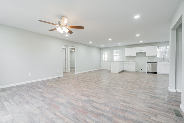 unfurnished living room featuring ceiling fan, sink, and light hardwood / wood-style flooring