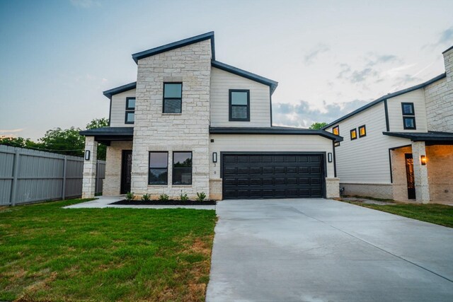 view of front of property featuring a garage and a front lawn