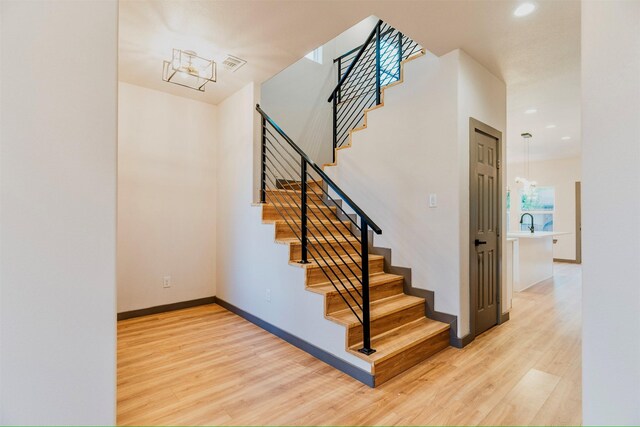 stairway featuring hardwood / wood-style floors and sink