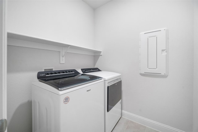 washroom featuring light tile patterned flooring, separate washer and dryer, and electric panel