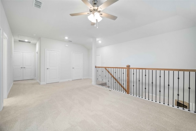 carpeted empty room with vaulted ceiling and ceiling fan