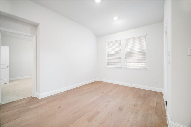 empty room featuring lofted ceiling and light hardwood / wood-style floors