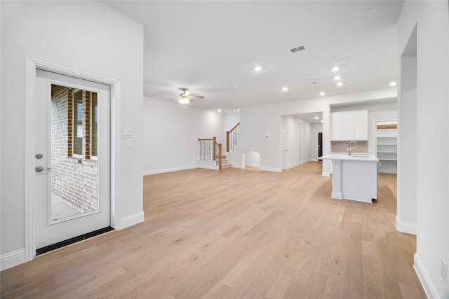 unfurnished living room with light hardwood / wood-style floors and ceiling fan