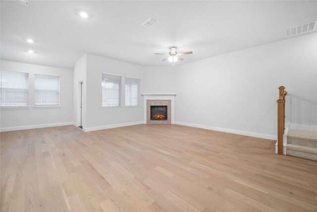 unfurnished living room with a fireplace, light hardwood / wood-style floors, and ceiling fan