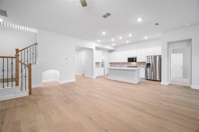 unfurnished living room with ceiling fan and light wood-type flooring