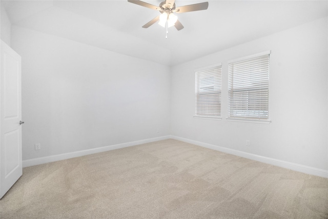 carpeted spare room featuring lofted ceiling and ceiling fan