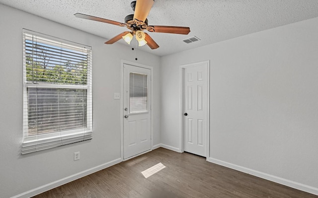 entrance foyer featuring visible vents, baseboards, a ceiling fan, and wood finished floors