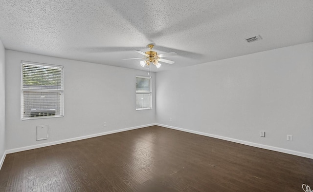 unfurnished room featuring visible vents, baseboards, dark wood-type flooring, and ceiling fan