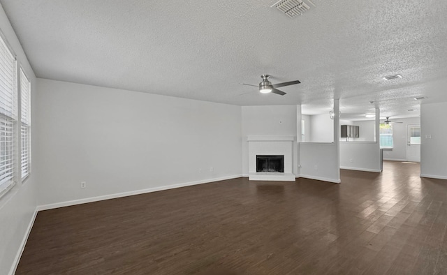 unfurnished living room featuring a textured ceiling, ceiling fan, and dark hardwood / wood-style floors