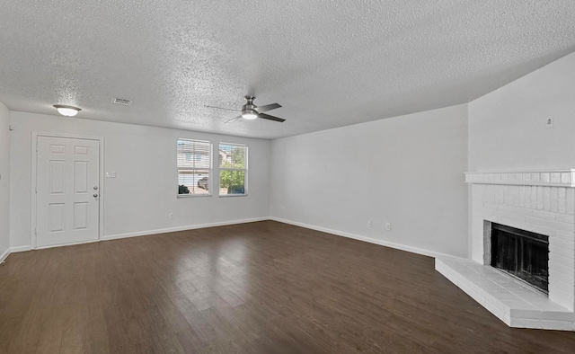 unfurnished living room featuring a textured ceiling, ceiling fan, hardwood / wood-style floors, and a brick fireplace