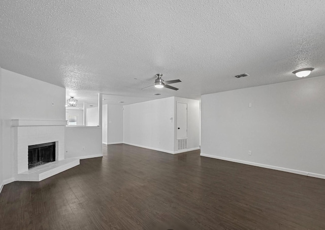 unfurnished living room featuring baseboards, visible vents, ceiling fan, dark wood-type flooring, and a brick fireplace