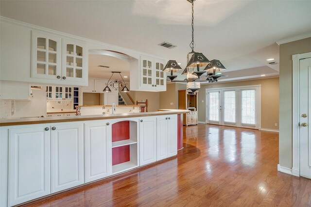 kitchen featuring an inviting chandelier, white cabinets, light hardwood / wood-style floors, and decorative light fixtures