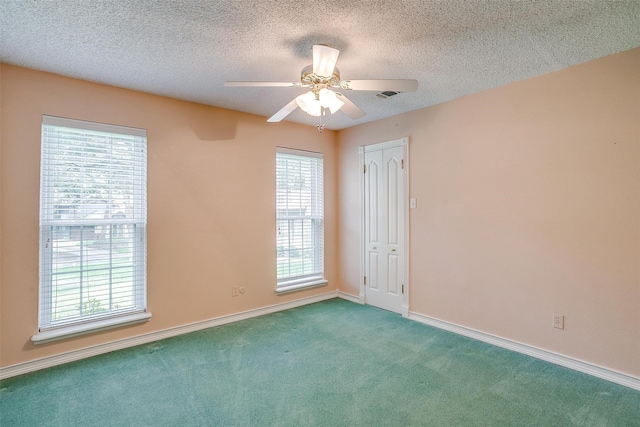 spare room featuring a textured ceiling, carpet flooring, and ceiling fan